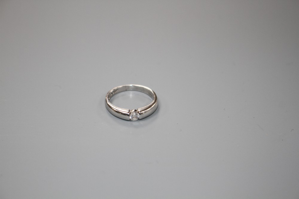 A modern 18ct white gold channel set solitaire diamond ring, size L, gross weight 3.6 grams.